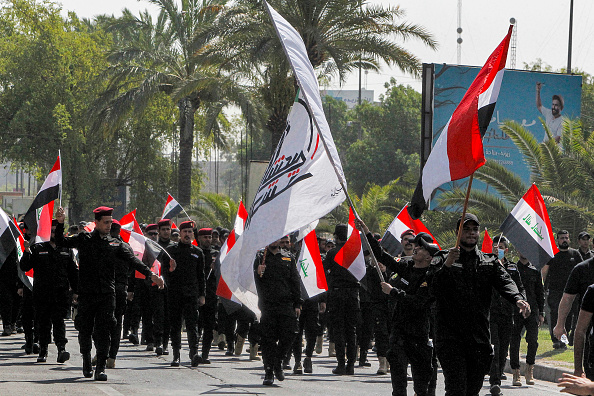 -Des membres des forces paramilitaires irakiennes défilent lors d'un défilé funéraire symbolique dans la capitale Bagdad le 29 juin 2021. Photo Sabah ARAR / AFP via Getty Images.