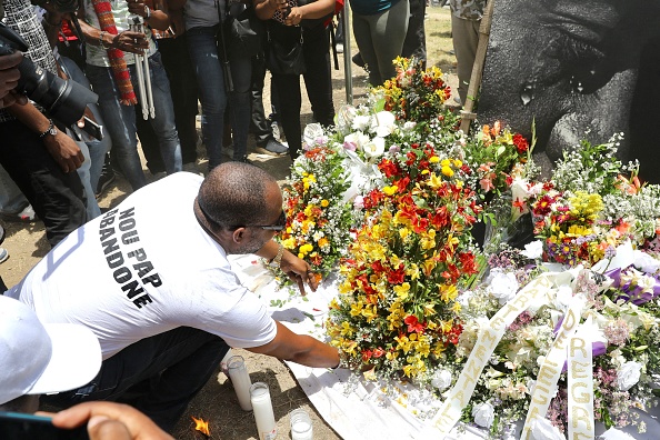 -Les gens rendent hommage à l'extérieur du palais présidentiel à Port-au-Prince le 14 juillet 2021, à la suite de l'assassinat du président haïtien Jovenel Moise survenu tôt le 7 juillet 2021. Photo by Valerie Baeriswyl / AFP via Getty Images.