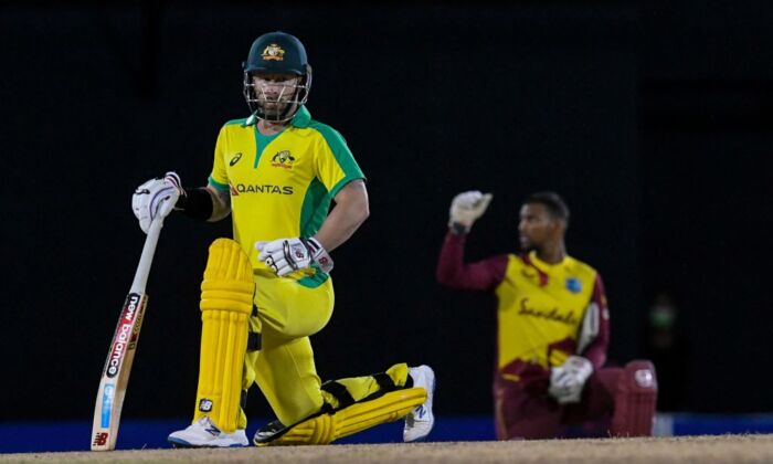 Matthew Wade (G) de l'Australie s'agenouille pour Black Lives Matter pendant le 4e T20I entre l'Australie et les Antilles au Darren Sammy Cricket Ground, à Gros Islet, dans le pays insulaire caribéen de Sainte-Lucie, le 14 juillet 2021. (Randy Brooks/AFP via Getty Images)
