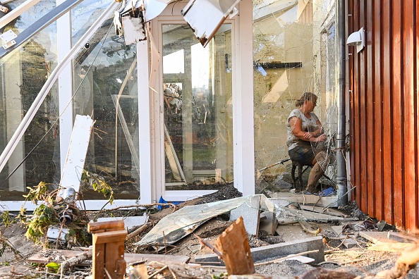 -Une femme se repose dans un jardin d'hiver détruit à Bad Neuenahr- Ahrweiler, dans l'ouest de l'Allemagne, le 17 juillet 2021. Photo by CHRISTOF STACHE/AFP via Getty Images.