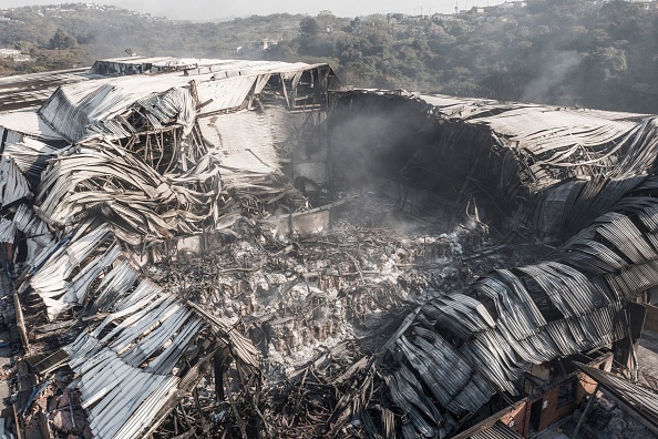 -Cette vue aérienne prise à Durban, le 20 juillet 2021, montre les vestiges fumants des installations d'Amcor Flexibles ZA. Photo de MARCO LONGARI / AFP via Getty Images.