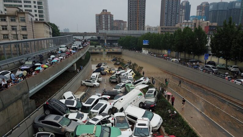 Une vue aérienne montre des voitures gisant dans les eaux de crue à l'entrée d'un tunnel après les fortes pluies qui ont frappé la ville de Zhengzhou, dans la province du Henan, en Chine centrale, le 22 juillet 2021. (NOEL CELIS/AFP via Getty Images)