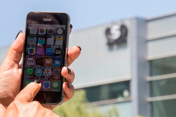 -Une Israélienne utilise son iPhone devant le bâtiment abritant le groupe israélien NSO, le 28 août 2016, à Herzliya, près de Tel Aviv. Photo de JACK GUEZ / AFP via Getty Images.