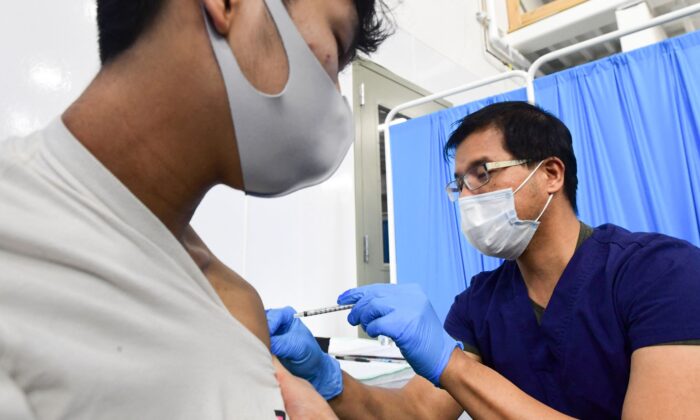 Robert Orallo, infirmier diplômé, administre le vaccin Pfizer Covid-19 à la Banque du sang d'Alaska à Anchorage, le 19 mars 2021. (Frederic J. Brown/AFP via Getty Images)