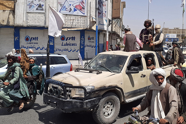 Des combattants talibans conduisent un véhicule de l'armée nationale afghane dans une rue de Kandahar le 13 août 2021. Photo de -/AFP via Getty Images.