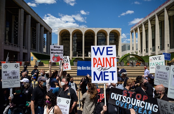 -Des travailleurs des coulisses, des musiciens, des chanteurs d'opéra et des partisans du Métropolitain Opera manifestent devant le Lincoln Center Plaza le 13 mai 2021 à New York. Photo par Angela Weiss / AFP via Getty Images.