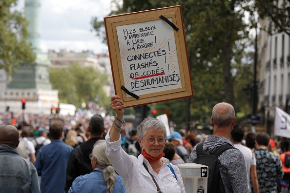 "Pas besoin d'apprendre à lire et à écrire ! Scanné, connecté... déshumanisé'. Journée nationale de protestation contre la vaccination Covid-19 obligatoire pour certains travailleurs et l'utilisation obligatoire du pass sanitaire. Paris le 31 juillet 2021. (Photo : GEOFFROY VAN DER HASSELT/AFP via Getty Images)