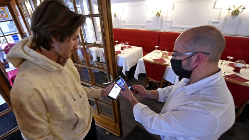 Contrôle du QR code d'un client dans un restaurant à Lille, le 10 août 2021. (photo FRANCOIS LO PRESTI/AFP via Getty Images)