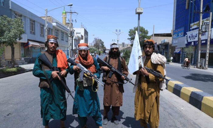 Des combattants talibans montent la garde le long d'une route à Herat, près du site de commémoration de l’événement religieux Achoura, le 19 août 2021. (Aref Karimi/AFP via Getty Images)