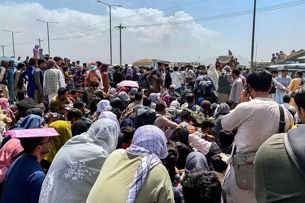 Des Afghans attendent de monter à bord d'un avion militaire pour quitter le pays, à l'aéroport militaire de Kaboul, le 20 août 2021. (Photo :  WAKIL KOHSAR/AFP via Getty Images)