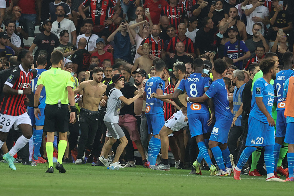 Des supporters envahissent le terrain pendant le match de football de L1 entre l'OGC Nice et l'Olympique de Marseille (OM) au stade Allianz Riviera à Nice, le 22 août 2021. (Photo : VALERY HACHE/AFP via Getty Images)