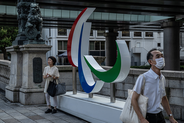 -Une femme pose pour une photo à côté des anneaux paralympiques de Tokyo le 27 août 2021, Japon. Photo de Carl Court/Getty Images.