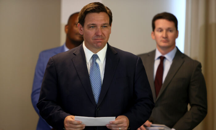 Le gouverneur de la Floride, Ron DeSantis, attend de présenter un chèque à un secouriste. L'événement de remise de primes s'est tenu au Grand Beach Hotel Surfside, à Surfside, en Floride, le 10 août 2021. Ron DeSantis a distribué certains des chèques de 1 000 $ que le budget de l'État de Floride a adopté pour les premiers intervenants et les enseignants de l'État. (Joe Raedle/Getty Images)