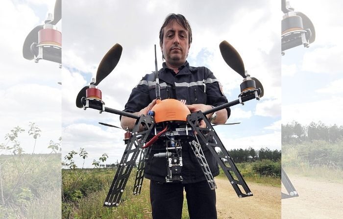 Un pompier français tient un aéronef sans pilote (UAV) (également connu sous le nom de drone) le 12 juillet 2012 près de Mont-de-Marsan, dans le sud-ouest de la France, au cours de tests réalisés dans la région forestière des Landes en tant que système innovant de surveillance des forêts qui permettra de suivre en temps réel les départs de feu et le développement des flammes dans les forêts du sud-ouest de la France. (PIERRE ANDRIEU/AFP/GettyImages)  