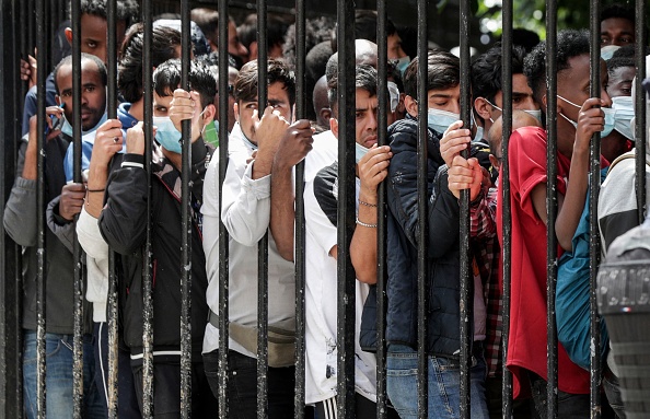 Des migrants et des sans-abri attendent d'être logés. Place des Vosges à Paris, le 30 juillet 2021, (Photo : GEOFFROY VAN DER HASSELT/AFP via Getty Images)