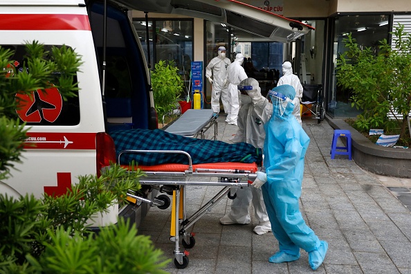 -Des travailleurs médicaux vietnamiens transfèrent un patient atteint de coronavirus dans une ambulance à l'hôpital de campagne, le Vietnam fait face à une quatrième vague brutale du virus. Photo par STR/AFP via Getty Images.