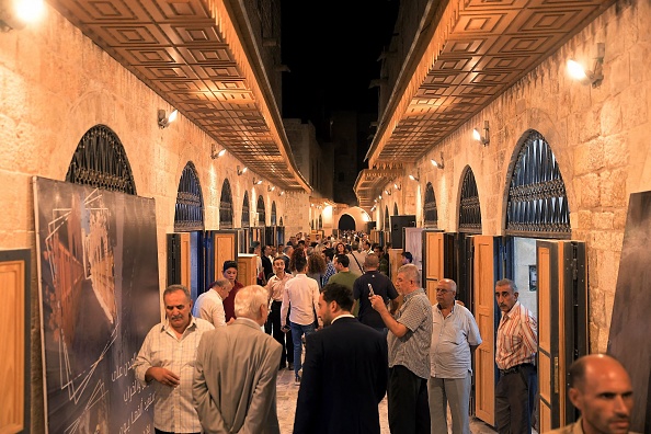 Des gens se promènent dans le "Souq Khan al-Harir" (marché couvert du khan de la soie) rouvert dans la ville d'Alep, dans le nord de la Syrie, le 29 août 2021. Photo de -/AFP via Getty Images.