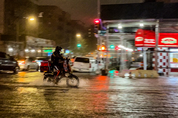 -Un livreur se fraie un chemin sous les précipitations de l'ouragan Ida le 1er septembre 2021, dans le quartier du Bronx à New York. Photo de David Dee Delgado/Getty Images.