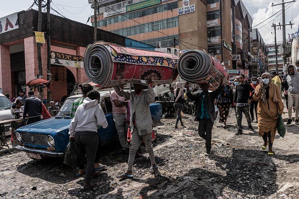 -Des travailleurs portent des tapis sur la tête dans le quartier historique de Merkato lors des préparatifs de la veille du Nouvel An éthiopien à Addis-Abeba, en Éthiopie, le 8 septembre 2021. Photo par Amanuel Sileshi / AFP via Getty Images.