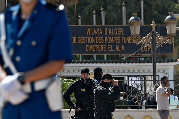 -Les forces de sécurité algériennes montent la garde devant le cimetière d'El-Alia où Abdelaziz Bouteflika, le président le plus ancien du pays d'Afrique du Nord, doit être enterré dans la capitale Alger le 19 septembre 2021. Photo de RYAD KRAMDI / AFP via Getty Images.