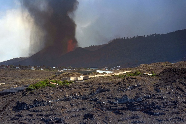 Une colonne de fumée et de matériaux pyroclastiques crachés par le volcan Cumbre Vieja est vue depuis la mer au large de Los Llanos de Aridane sur l'île canarienne de La Palma le 23 septembre 2021.  (DESIREE MARTIN/AFP via Getty Images)