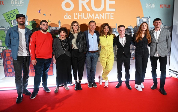 L'acteur et réalisateur français Dany Boon (C), l'acteur français Tom Leeb (G), l'actrice française Liliane Rovere (3L), l'actrice française Laurence Arne (4L), la comédienne et actrice belge Nawell Madani (4R) et la comédienne et actrice française Alison Wheeler (2R) posent avec Leo, Franck et Wilfried, trois jeunes qui se sont portés volontaires pendant les confinements  (DENIS CHARLET/AFP via Getty Images)