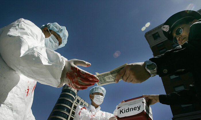 Des pratiquants de Falun Gong reconstituent le paiement illégal d'organes humains à Washington, le 19 avril 2016. (Jim Watson/AFP via Getty Images)