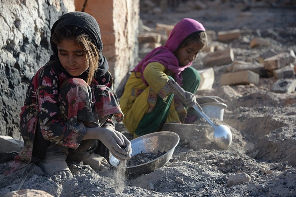 Des enfants afghans récupèrent du charbon dans une briqueterie pour leur maison à la périphérie de Kaboul le 1er juin 2018. Photo de NOORULLAH SHIRZADA / AFP via Getty Images.