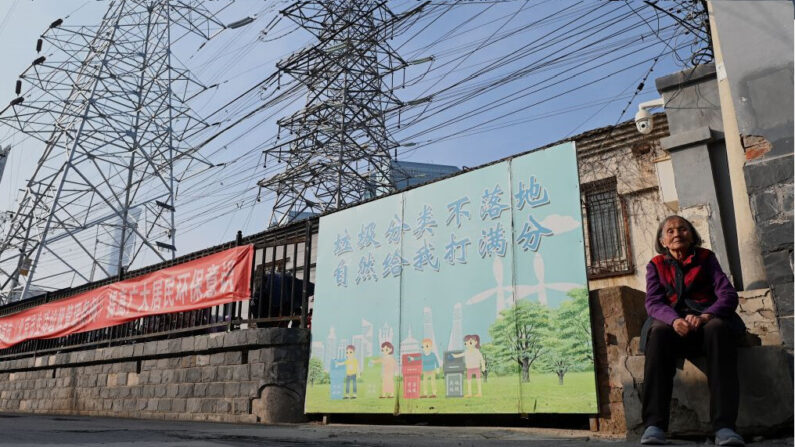 Une femme est assise sous des lignes électriques à Pékin, le 13 octobre 2021. (Photo par Noel CELIS / AFP) (Photo par NOEL CELIS/AFP via Getty Images)