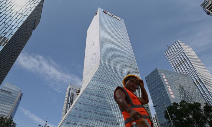 Un ouvrier marche devant le siège d'Evergrande à Shenzhen, dans le sud-est de la Chine, le 26 septembre 2021. (Noel Celis/AFP via Getty Images)