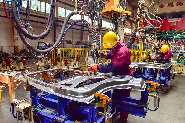 -Un ouvrier assemble un véhicule dans une usine de Qingzhou, dans la province chinoise du Shandong, dans l'est de la Chine, le 28 septembre 2021. Photo par STR/AFP via Getty Images.