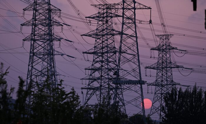 Coucher de soleil derrière des pylônes électriques à Pékin, le 28 septembre 2021. (Leo Ramirez/AFP via Getty Images)