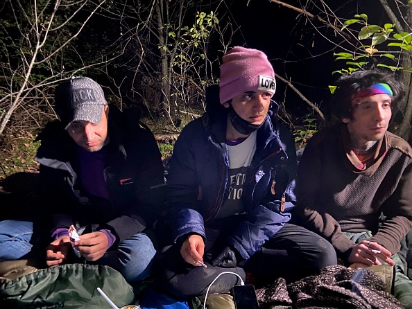 Trois migrants irakiens se cachant dans une forêt polonaise près de la ville polonaise de Chelm sont photographiés peu après avoir traversé la frontière depuis la Biélorussie, le 30 septembre 2021. (Photo : DARIO THUBURN/AFP via Getty Images)