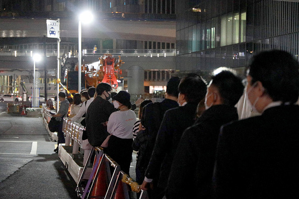 Les gens attendent à une station de taxis devant la gare de Shibuya à Tokyo le 8 octobre 2021 alors que les services ferroviaires sont suspendus. Photo par STR/JIJI PRESS/AFP via Getty Images.