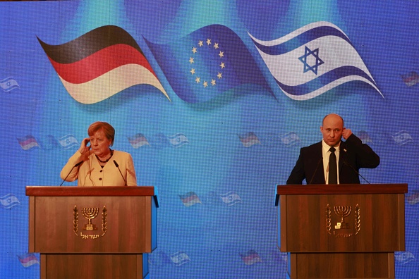 -La chancelière allemande Angela Merkel et le Premier ministre israélien Naftali Benett lors d'une conférence de presse à l'hôtel King David à Jérusalem, le 10 octobre 2021. Photo de Menahem KAHANA / AFP via Getty Images.