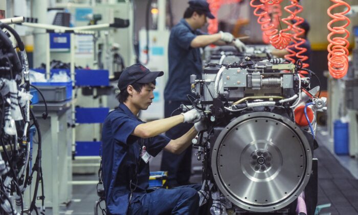 Un ouvrier fabrique des moteurs de poids lourds dans une usine à Hangzhou, dans la province du Zhejiang, en Chine, le 18 octobre 2021. (STR/AFP via Getty Images)