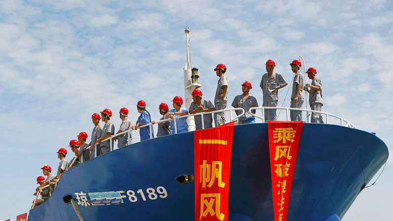 Personnel debout sur un bateau de pêche mettant le cap sur les îles Spratly, un archipel disputé entre la Chine et d'autres pays dont le Vietnam et les Philippines, le 6 mai 2013, à Danzhou. La Chine a envoyé l'une de ses plus grandes flottes de pêche enregistrées sur les îles contestées de la mer de Chine méridionale dans un contexte de tensions liées aux revendications de Pékin dans la région.  (STR/AFP via Getty Images)