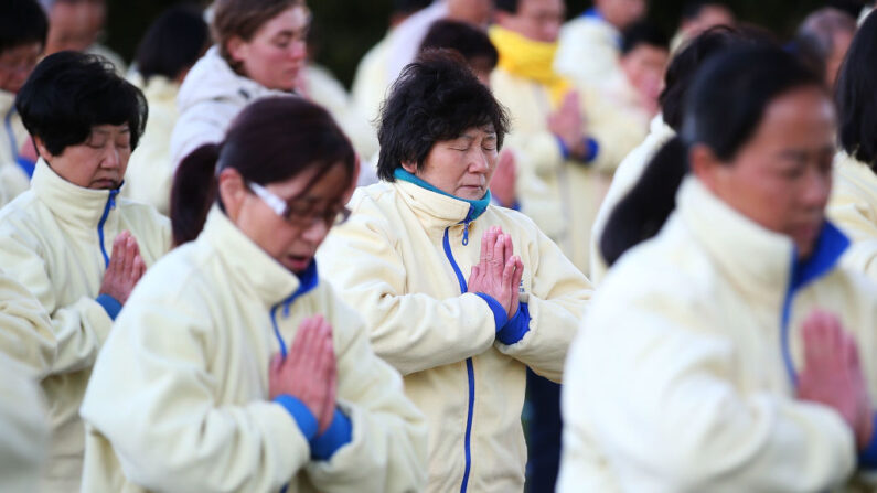 Des pratiquants de Falun Gong méditent lors de l' "anniversaire" du début de la persécution du Falun Gong en Chine, le 21 juillet 2013 à Sydney, en Australie. En juillet 1999, le gouvernement communiste chinois a mis hors la loi la pratique spirituelle du Falun Gong, la déclarant illégale et interdisant aux citoyens de la pratiquer.  Des milliers de pratiquants ont été tués, des centaines de milliers ont été emprisonnés ou mis dans des camps de travail en Chine depuis 1999. (Brendon Thorne/Getty Images)