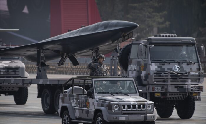 Un soldat chinois salue devant un drone militaire lors d'un défilé pour célébrer le 70e anniversaire de la fondation du régime communiste chinois sur la place Tiananmen à Pékin, le 1er octobre 2019. (Kevin Frayer/Getty Images)