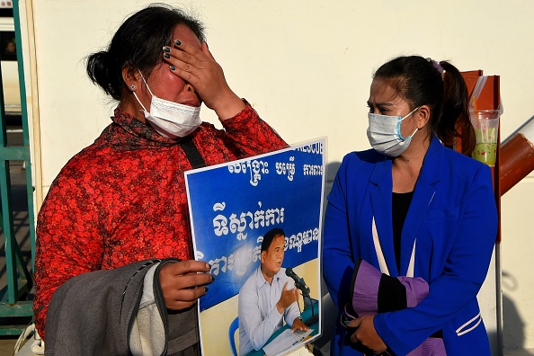 Prum Chantha épouse du militant du CNRP emprisonné Kak Komphear, pleure alors qu'elle tient une photo de son mari devant le tribunal municipal de Phnom Penh à Phnom Penh le 14 janvier 2021. Photo de TANG CHHIN SOTHY / AFP via Getty Images.