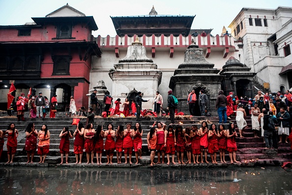 Des dévots hindous exécutent un bain cérémonial dans la rivière sacrée, au temple de Pashupatinath à Katmandou le 11 février 2021. Photo par Prakash MATHEMA/AFP via Getty Images.