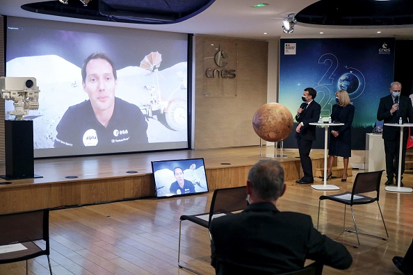 -L'astronaute français Thomas Pesquet apparaît sur un écran pour prononcer un discours aux côtés du président français Emmanuel Macron et de son épouse Brigitte Macron, à Paris le 18 février 2021. Photo Christophe PETIT TESSON / POOL / AFP via Getty Images.