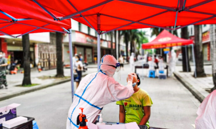 Un résident subit un test d'acide nucléique pour le coronavirus Covid-19 dans la ville de Ruili, à la frontière avec le Myanmar, dans la province chinoise du Yunnan (sud-ouest), le 5 juillet 2021. (STR/AFP via Getty Images)