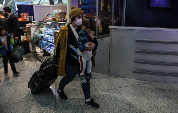 Une femme irakienne portant un enfant arrive à l'aéroport d'Arbil, la capitale de la région autonome kurde du nord de l'Irak, après avoir été ramenée par avion de la capitale biélorusse Minsk, le 18 novembre 2021. (Photo : SAFIN HAMED/AFP via Getty Images)