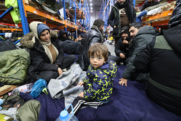 Des migrants restent dans le centre de transport et de logistique près du point frontalier de Bruzgi, à la frontière biélorusse et polonaise, dans la région de Grodno, le 19 novembre 2021.(Photo : MAXIM GUCHEK/BELTA/AFP via Getty Images)