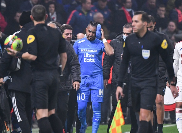 Dimitri Payet quitte le terrain après avoir reçu une bouteille d'eau de la tribune lors du match de football de L1 française entre l'Olympique Lyonnais et l'Olympique de Marseille. (Photo : PHILIPPE DESMAZES/AFP via Getty Images)