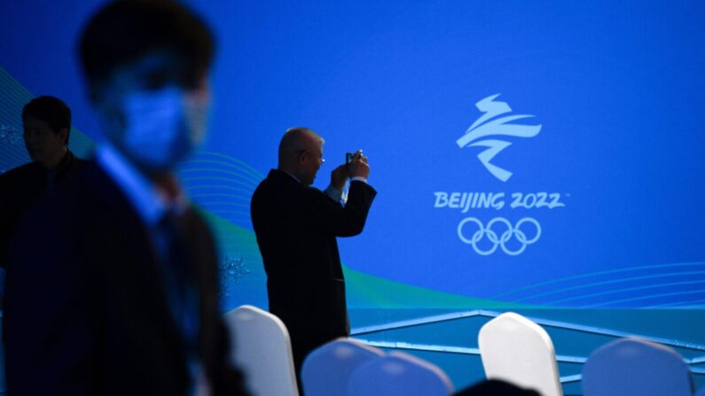 Un homme prend en photo le logo des Jeux olympiques d'hiver de Pékin 2022 lors de l'événement du compte à rebours des 100 jours des Jeux paralympiques d'hiver de Pékin 2022 au Centre aquatique national de Pékin, le 24 novembre 2021. (Wang Zhao/AFP via Getty Images)
