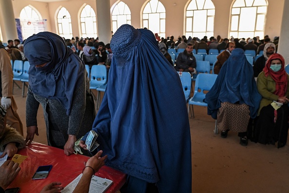 -Une femme portant une burqa reçoit de l'argent du Programme alimentaire mondial à Kaboul le 29 novembre 2021. Photo par Hector RETAMAL / AFP via Getty Images.