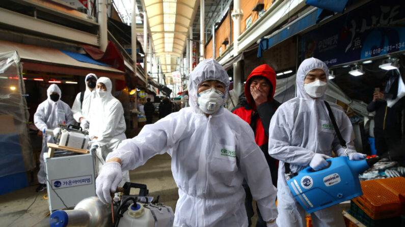 Une équipe de désinfection  pulvérise une solution antiseptique contre le virus du PCC dans un marché traditionnel de Séoul, en Corée du Sud, le 26 février 2020. (Chung Sung-Jun/Getty Images)