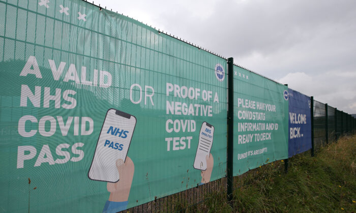 Des conseils sur le pass sanitaire NHS et le test négatif relatifs au Covid sont affichés sur une bannière à l'extérieur du stade avant le match de Premier League entre Brighton & Hove Albion et Watford au stade American Express Community Stadium à Brighton, en Angleterre, le 21 août 2021. (Steve Bardens/Getty Images)